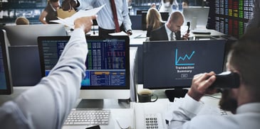 Men in the office looking at financial data on their computers