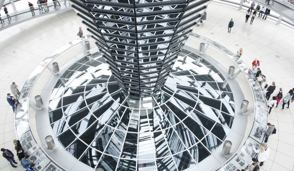 People sitting around a metal tower in a government building