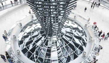 People sitting around a metal tower in a government building