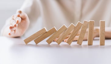 hand pushing wooden dominoes
