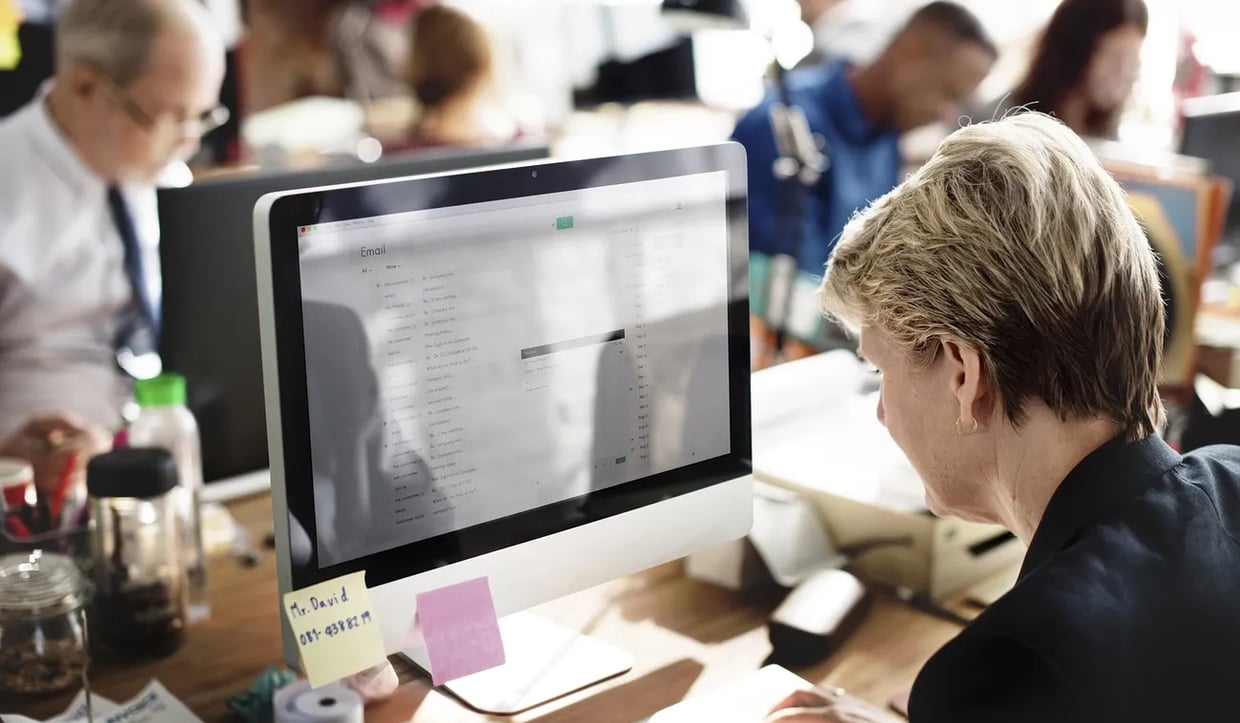 Short-haired blonde woman reading her emails on the computer